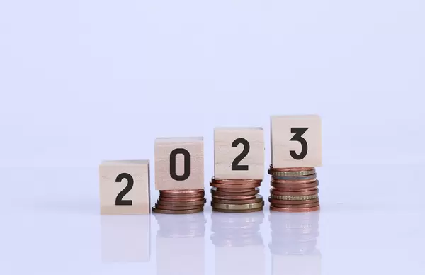 Coin stacks and wooden blocks with 2023 text