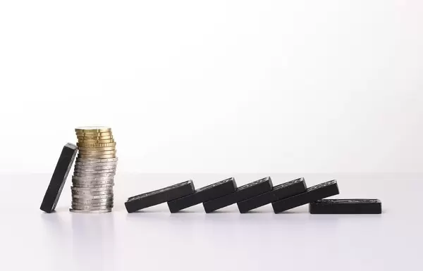 Coins and dominoes. Concept of the financial crisis