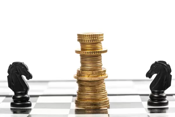 Coins stacked like a king on a chessboard and two black horses