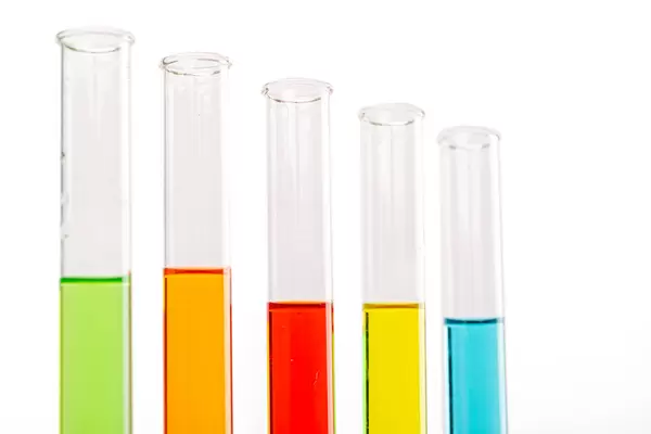 Colored liquids in five test tubes over white background