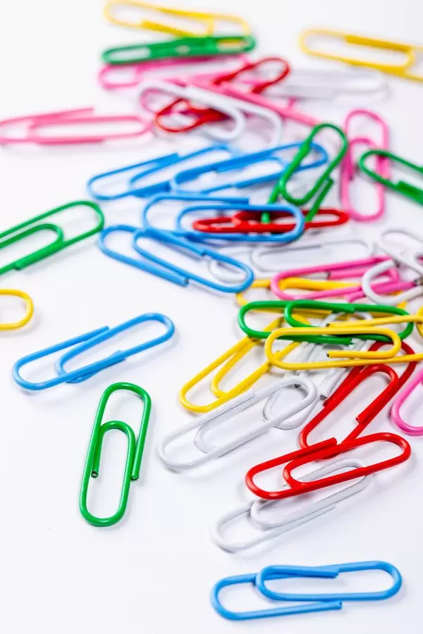 Colored paper clips on white background