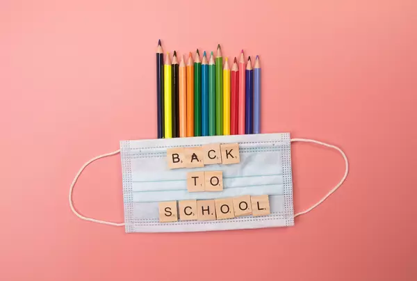 Colored pencils and medical face mask with back to School text