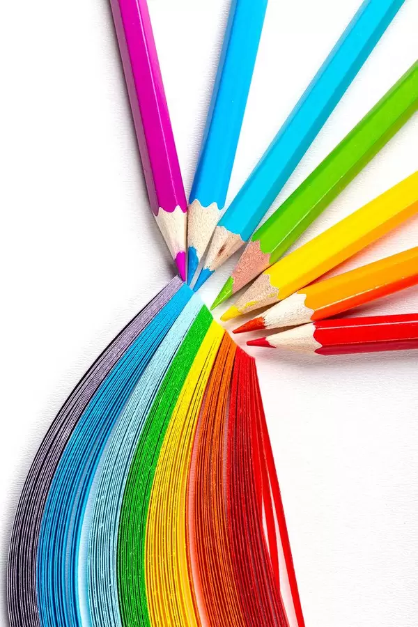 Colored pencils and rainbow made of colored paper