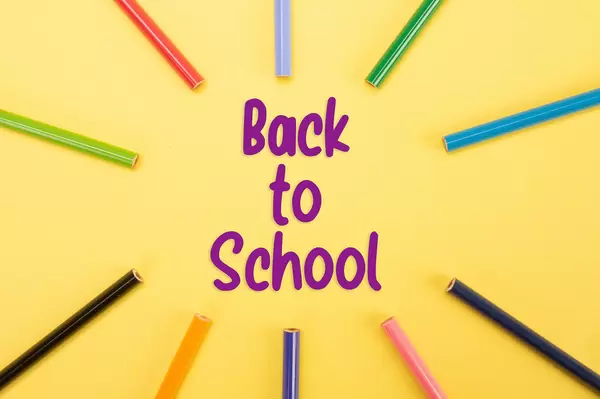 Colored pencils with Back to School text on yellow backgorund