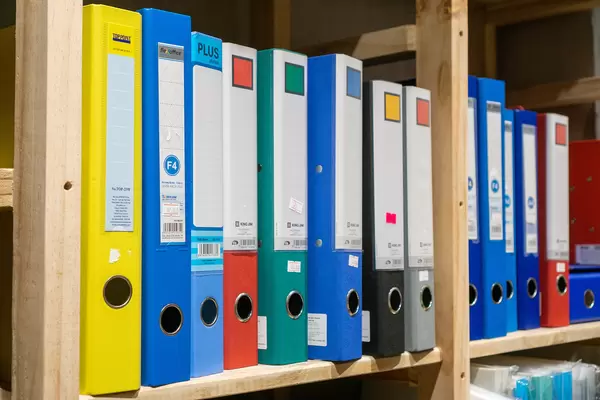 Colorful A4 Box Files with Price Tags in a Wooden Shelf in a Bookstore