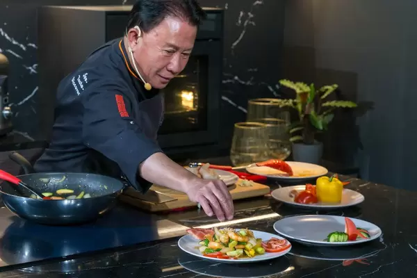 Colorful asian food by professional chef Martin Yan during a cooking show at German exhibition IFA: Shrimps and vegetables