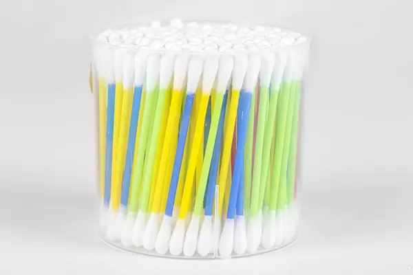 Colorful cotton swabs on light background