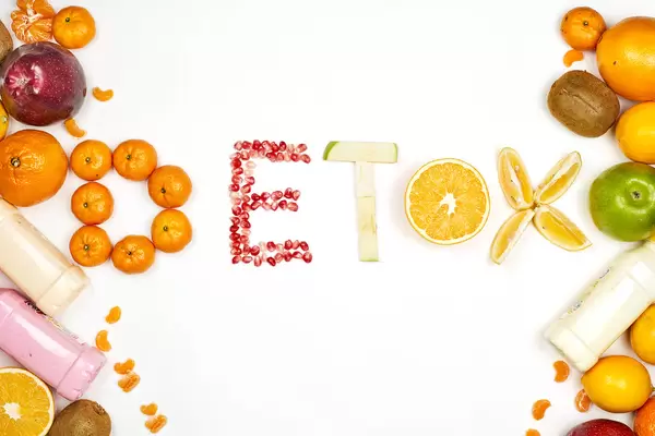 Colorful fruit background with - Detox word made with different raw fruits slices