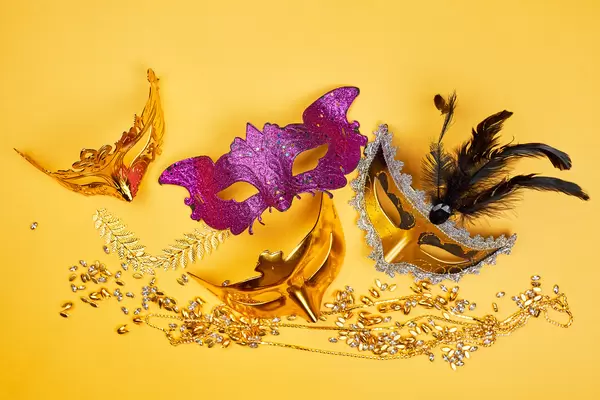 Colorful Mardi Gras masks on yellow background