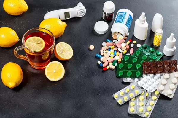 Colorful medicines and pills with a Cup of tea and lemons. Concept folk medicine and traditional medicine (Flip 2019)