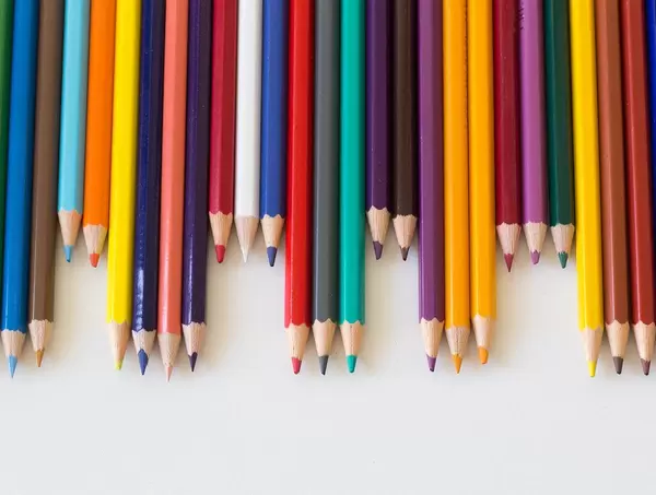 Colorful Pencils laying next to each other on white Background