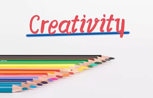 Colorful pencils on white background with text Creativity