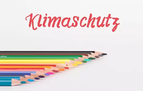 Colorful pencils on white background with text Klimaschutz