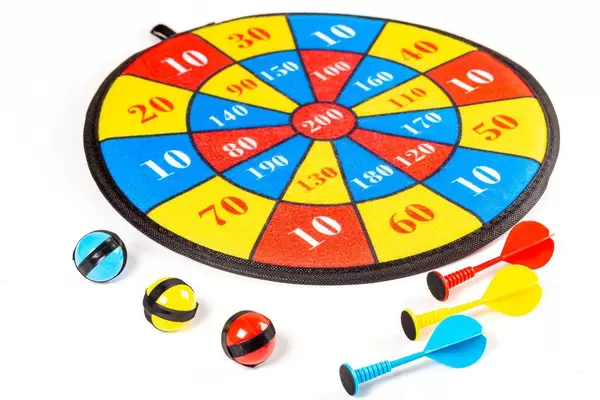 Colorful round target on white background with darts and velcro balls