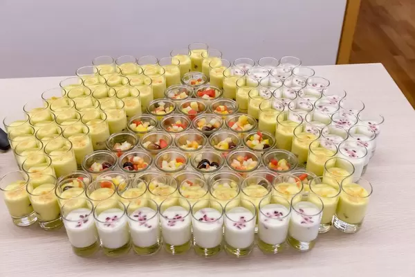 Colourful fruit salad and saffron yoghurt in decorative dessert glasses at a food buffet of the Barcamp OMWest19 by AXA in Cologne, Germany