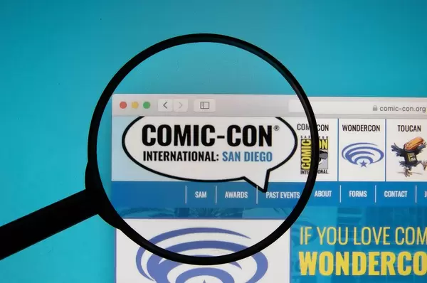 Comic-Con International website on a computer screen with a magnifying glass