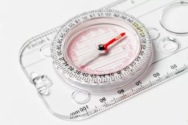 Compact compass with ruler on white background close-up (Flip 2020)