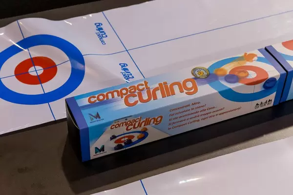 Compact curling Verpackung und Curling Bahn im Hintergrund