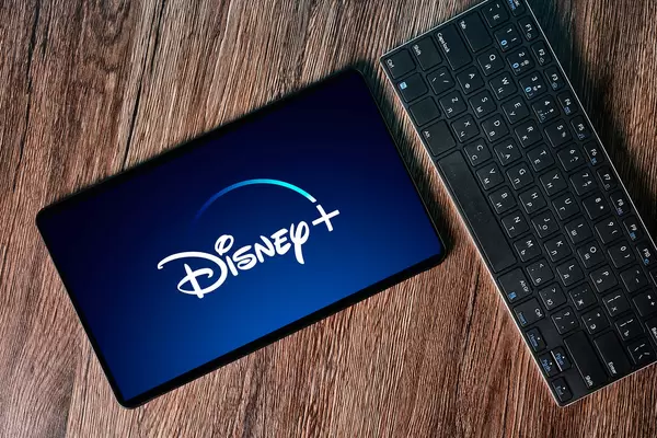Computer keyboard and tablet with Disney+ logotype on display