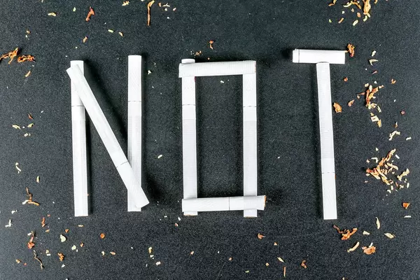 Concept against drugs. The word NOT laid out from cigarettes on a black background