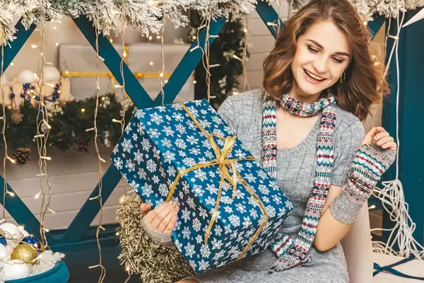 Concept of christmas surprise, gift in hand of happy girl