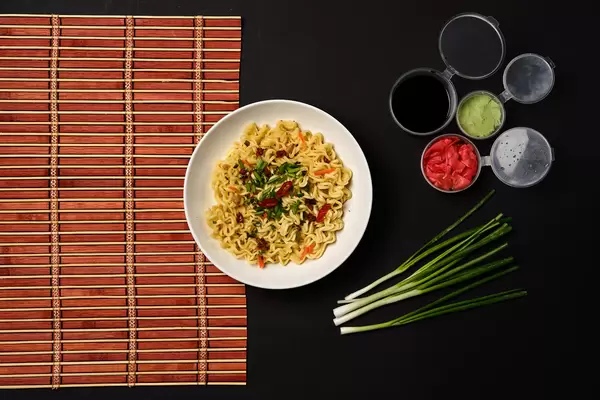 Concept of tasty eating with bowl of noodles on dark background
