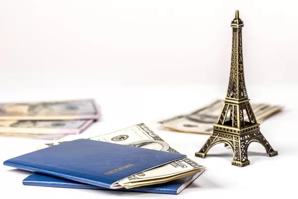 Concept of travel, vacation or leisure planning. Money, two passports and the Eiffel tower