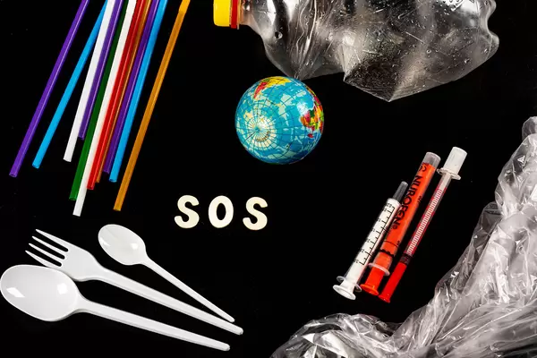 Concept pollution of environment with polyethylene plastic waste, ecological problems, and the word stop made of wooden letters