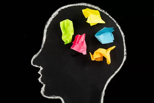 Concepts for generating ideas and solutions, multicolored papers in a drawn head silhouette