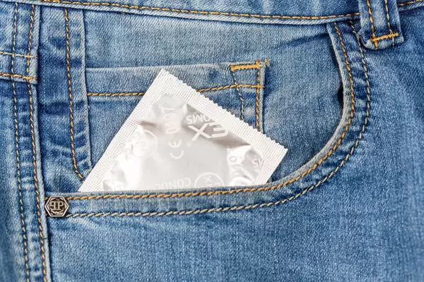 Condom in the pocket of men's denim pants