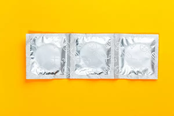 Condoms on a yellow background. Top view (Flip 2019)