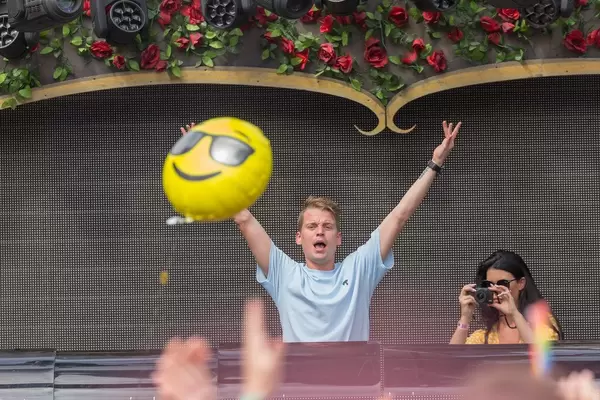 Conro schafft die Party-Atmosphäre mit gehobenen Händen während jemand vom Publikum einen Smiley-Luftballon fliegt
