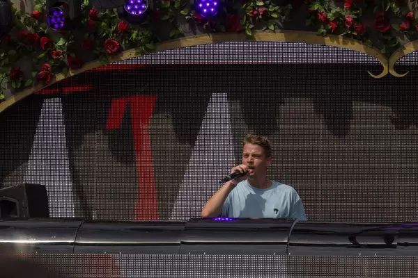 Conro talks to the visitors of Tomorrowland festival with huge visual screen in the background