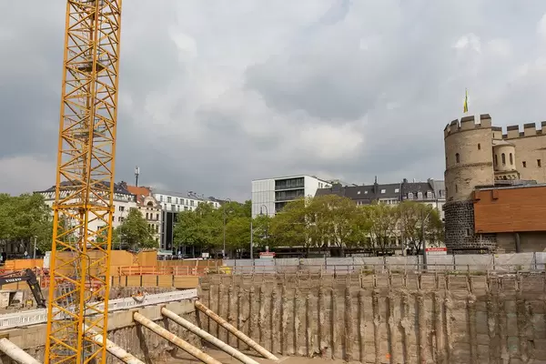 Construction with crane and excavator at Rudolfplatz in Cologne with the medieval city wall in the background