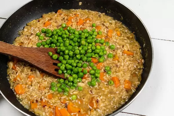 Cooked Integral Rice with Green Peas in the frying pan (Flip 2020)