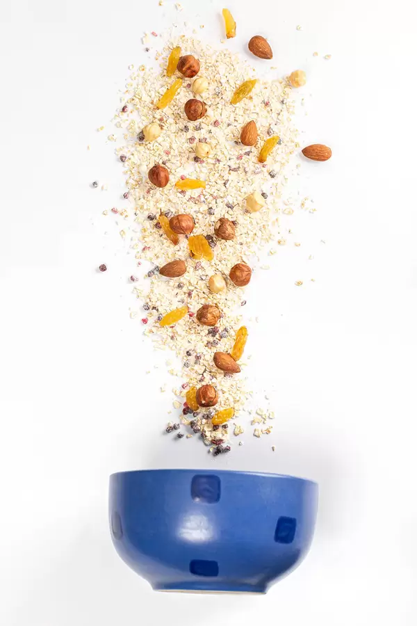 Cooking delicious and healthy breakfast concept, oatmeal with nuts and berries