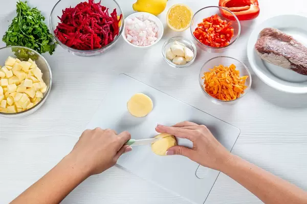 Cooking process on the kitchen table with ingredients for borscht (beet soup with meat) (Flip 2019)