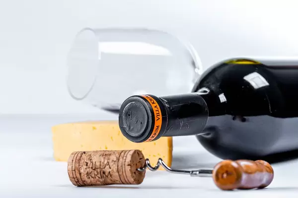 Corkscrew, wine bottle and glass on white background
