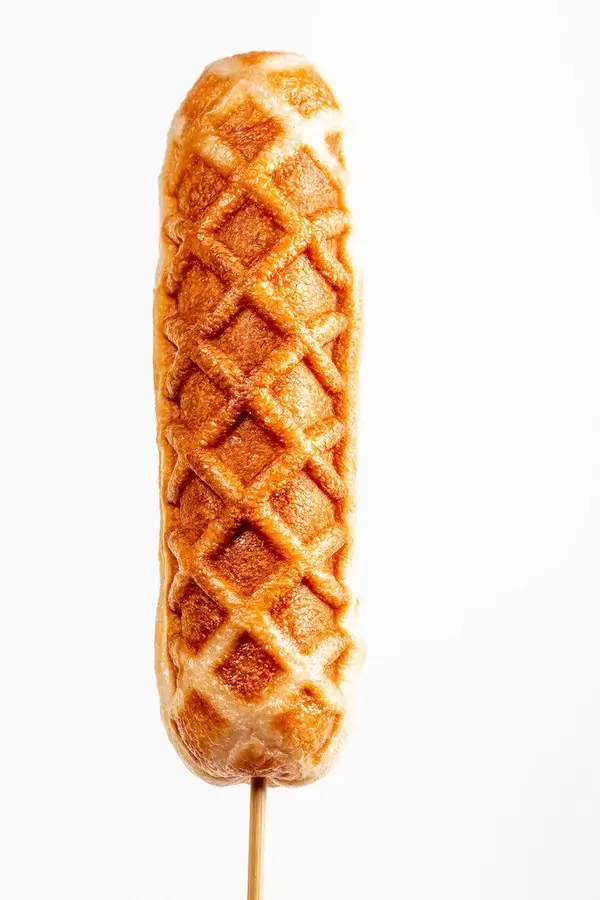 Corn dog on a stick on a white background