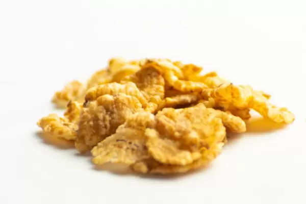 Corn flakes spilled on a white background