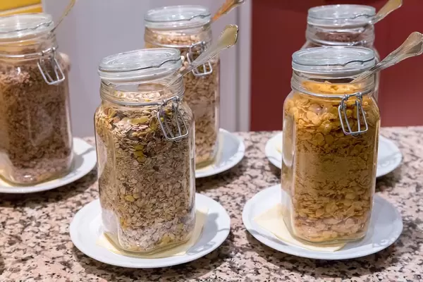 Cornflakes und diverse Müsli-Sorten in Glasbehältern