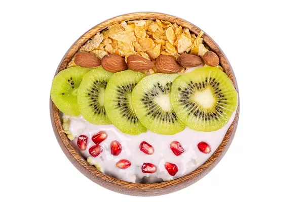Cornflakes with almonds, kiwi, pomegranate and yogurt, top view