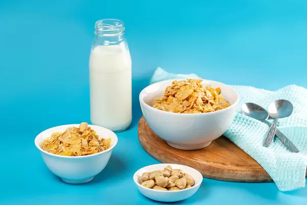 Cornflakes with milk for breakfast, blue background