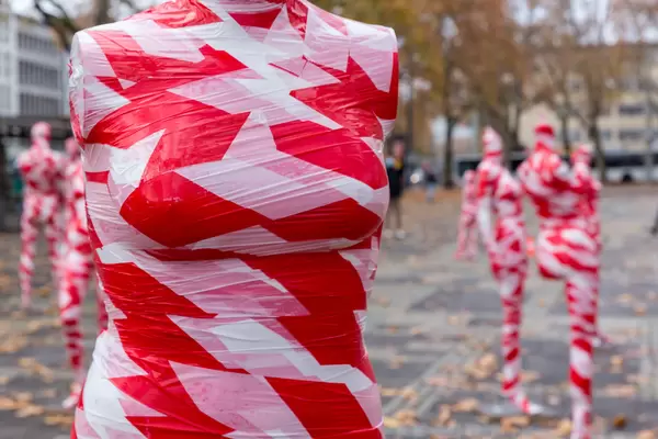 Corona-Installation: Nahaufnahme von Brust einer Schaufensterfigur in rot-weißem Band umwickelt