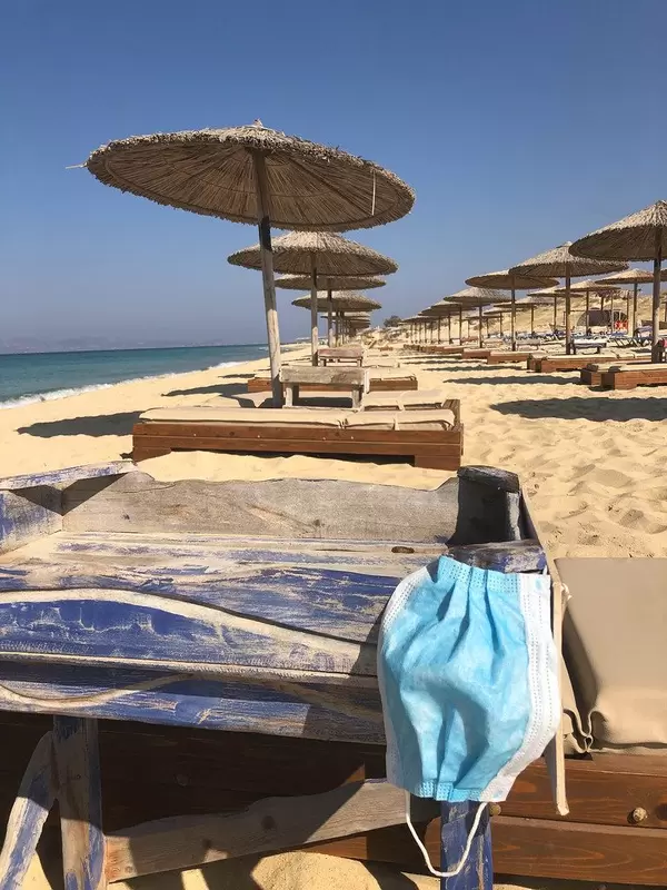 Corona-Maßnahmen im Urlaub: MNS-Maske zum Schutz vor Covid-19 am Sandstrand von Naxos, Griechenland