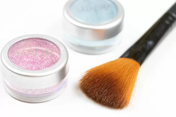 Cosmetics Brush with Glitters in the box above white background table