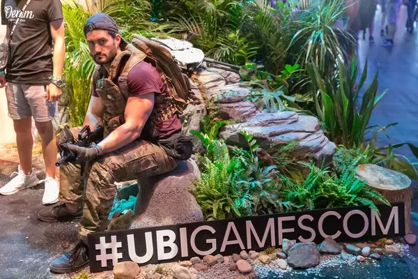 Cosplay auf der Gamescom 2019, nachgebaute Videospiellandschaft und der Hashtag #UBIGAMESCOM von Ubisoft
