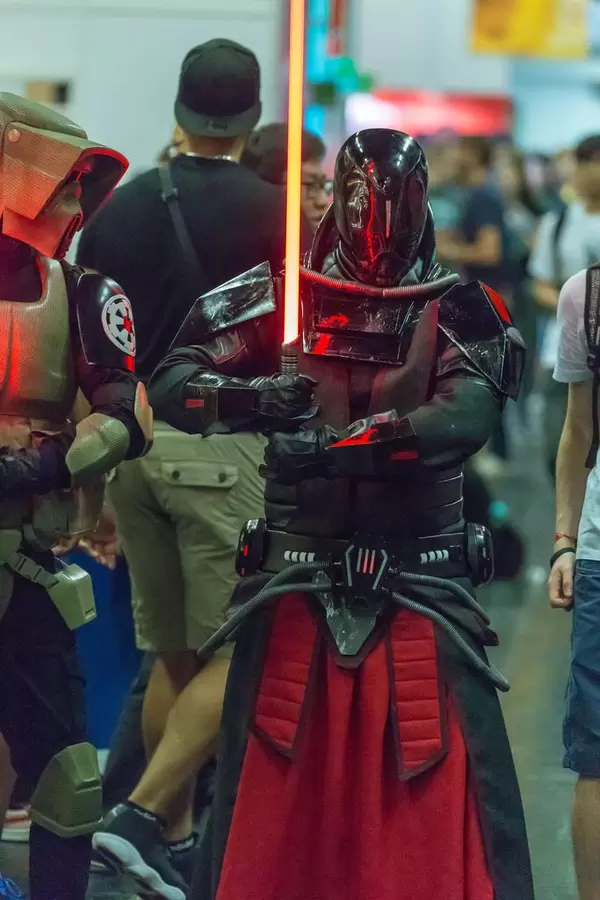 Cosplayer gekleidet als Sith Lord mit rotem Lichtschwert