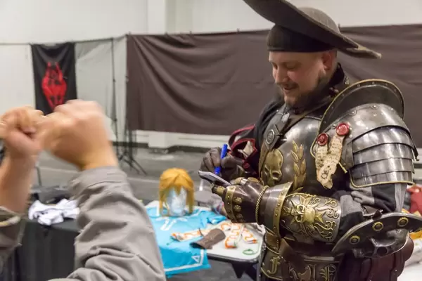 Cosplayer giving an autograph