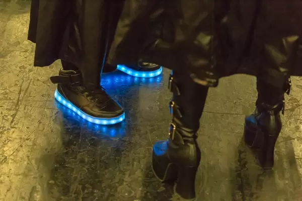 Cosplayer in schwarzes Leder gekleidet mit leuchtenden Schuhen